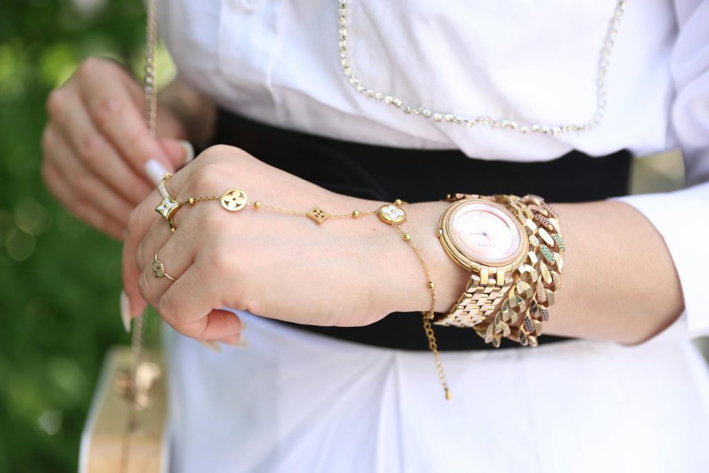 Close-up of a woman's wrist with elegant gold jewelry, showcasing style and luxury.