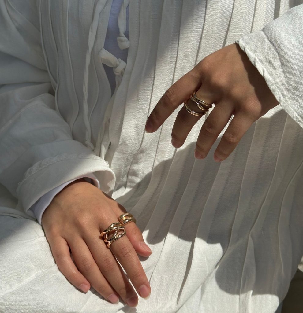 Stylish white outfit with elegant gold rings in natural sunlight, İzmir.