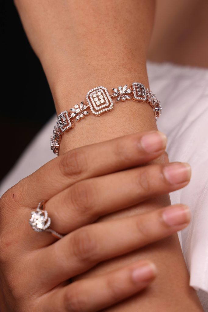 Close-up of a woman's hand showcasing a diamond bracelet and ring, highlighting their intricate design.