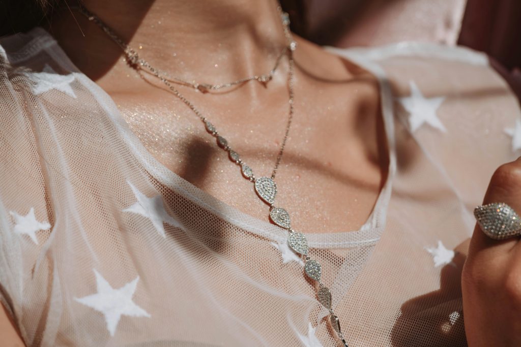 Close-up of a stylish diamond necklace on a star-patterned sheer fabric, capturing elegance.